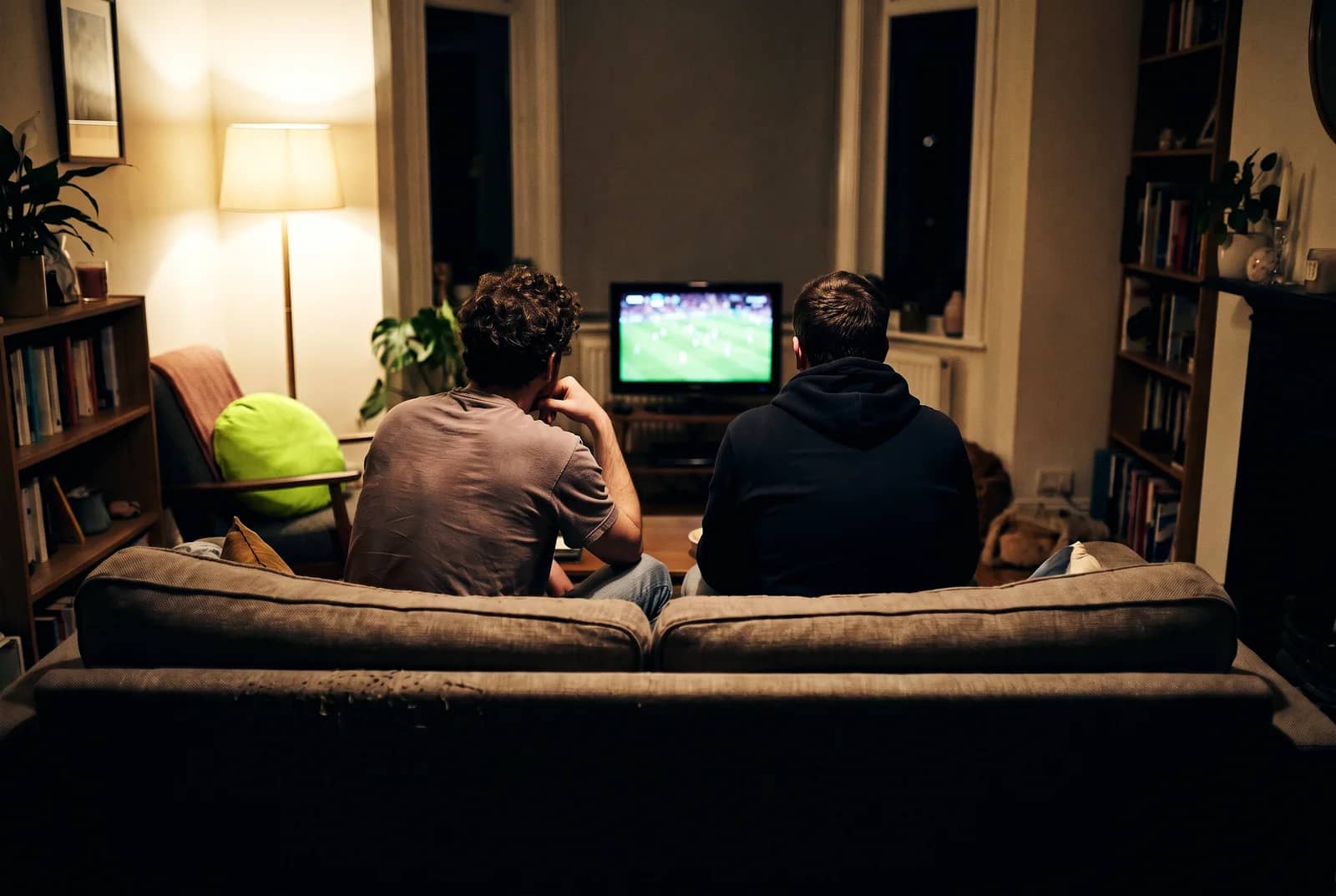 Amigos adultos assistindo a uma partida de futebol na sala